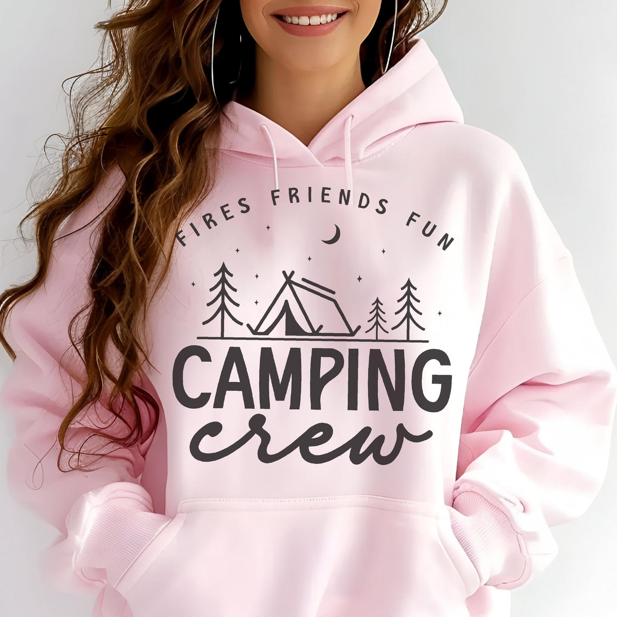May include: A light pink hoodie with a drawstring hood and front pocket. The front features a black graphic with the words "FIRES FRIENDS FUN" above a tent and trees, and "CAMPING crew" below.