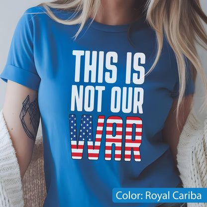 May include: Royal Cariba blue t-shirt with the text "THIS IS NOT OUR WAR" in white. The word "WAR" is designed with the American flag pattern. The shirt is a short-sleeved crew neck.