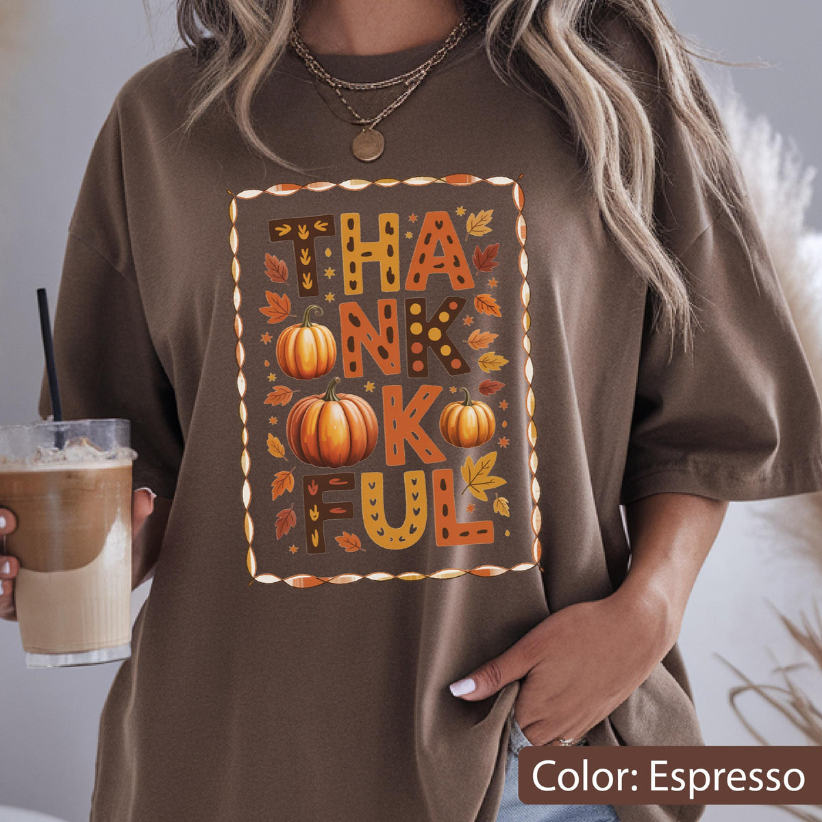 May include: Espresso-colored t-shirt with a rectangular graphic that reads "THANKFUL" in orange and brown letters. The graphic includes two pumpkins and fall leaves. The shirt is a comfortable, casual style.