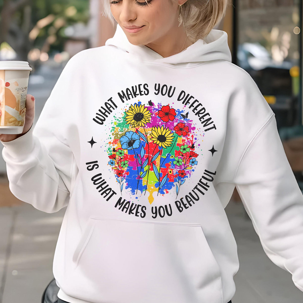May include: White hoodie with a colorful floral design and the text "WHAT MAKES YOU DIFFERENT IS WHAT MAKES YOU BEAUTIFUL". The design features sunflowers, red flowers, and blue flowers. The hoodie has a front pocket.