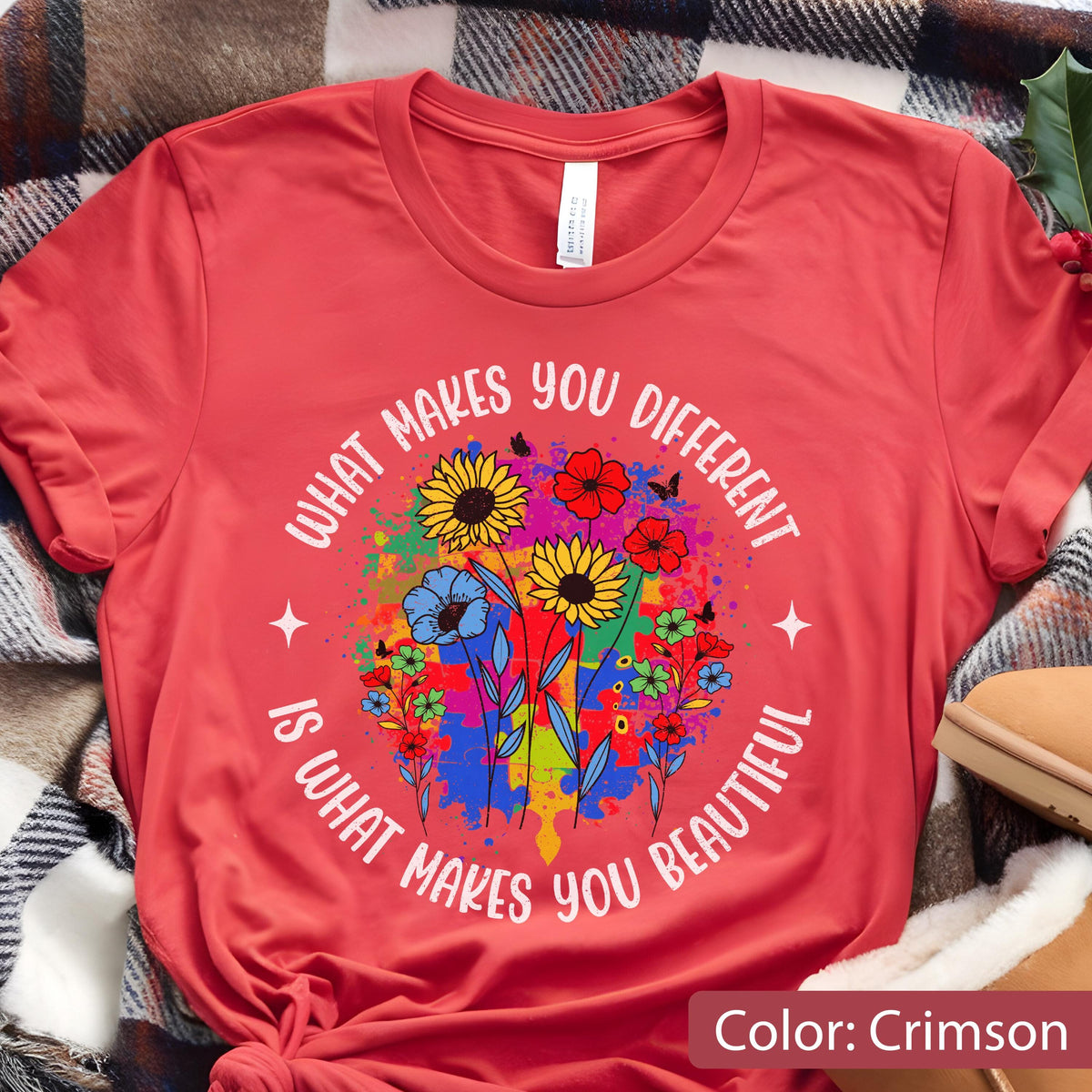 May include: Crimson-colored t-shirt featuring a colorful floral design with the text "WHAT MAKES YOU DIFFERENT IS WHAT MAKES YOU BEAUTIFUL" in a circular arrangement. The design includes sunflowers, blue flowers, and butterflies.