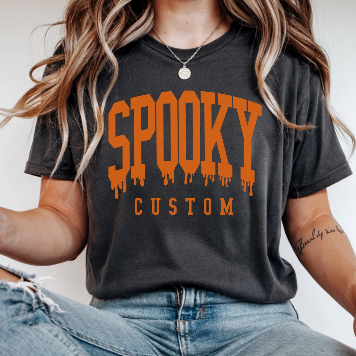 May include: A charcoal gray short-sleeve t-shirt featuring the word SPOOKY in large, orange, dripping varsity-style lettering across the chest, with the word CUSTOM printed in smaller, plain orange block letters directly underneath the main text.