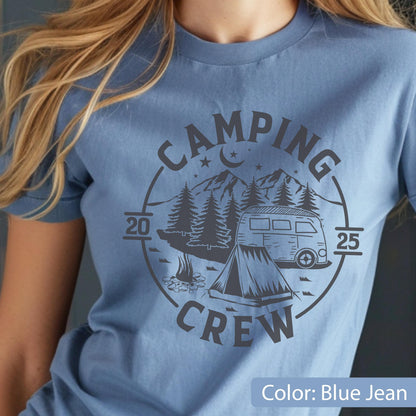 May include: A blue jean colored t-shirt featuring a dark gray circular graphic. The design includes the text CAMPING CREW, the numbers 20 and 25, a mountain range, pine trees, a crescent moon, stars, a camper van, and a tent with a campfire.