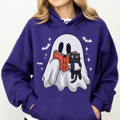 May include: A purple hoodie featuring a cartoon ghost reading a book and holding a black cat. The design includes bats and stars. The hoodie has a drawstring hood and a front pocket.
