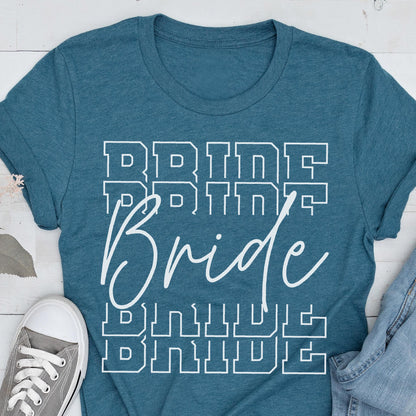May include: Teal-colored t-shirt with the word "Bride" in white, in a stacked design. The word "Bride" is written in a cursive font, with the word "Bride" stacked above and below in a block letter font.