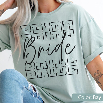 May include: A light green t-shirt with the word "Bride" in a black, bold, layered font. The word "Bride" is repeated multiple times in a stacked design. The shirt's color is labeled "Bay".