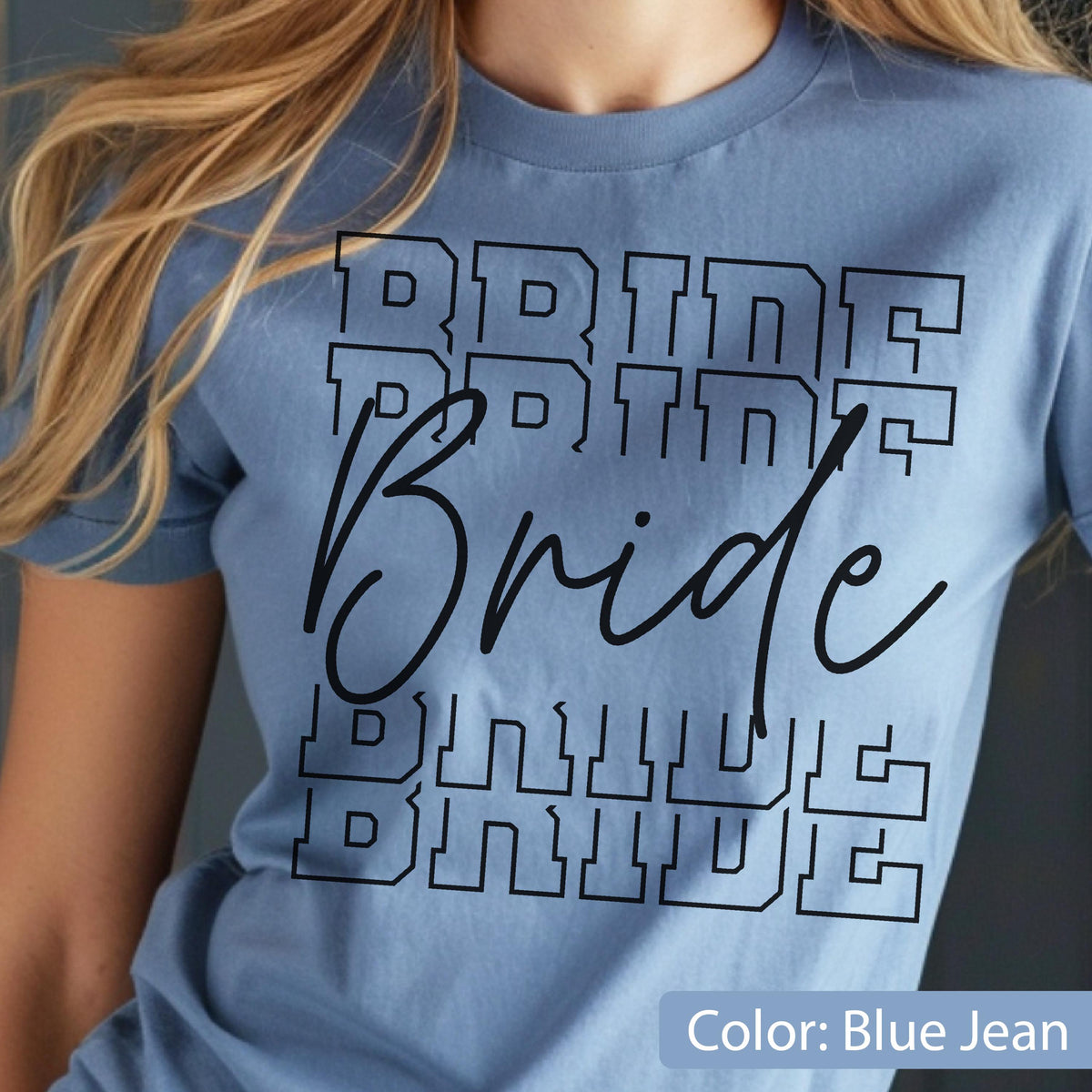 May include: A light blue t-shirt with the word "Bride" in a black, bold, layered font. The word is repeated multiple times. The shirt is a solid color and has short sleeves.