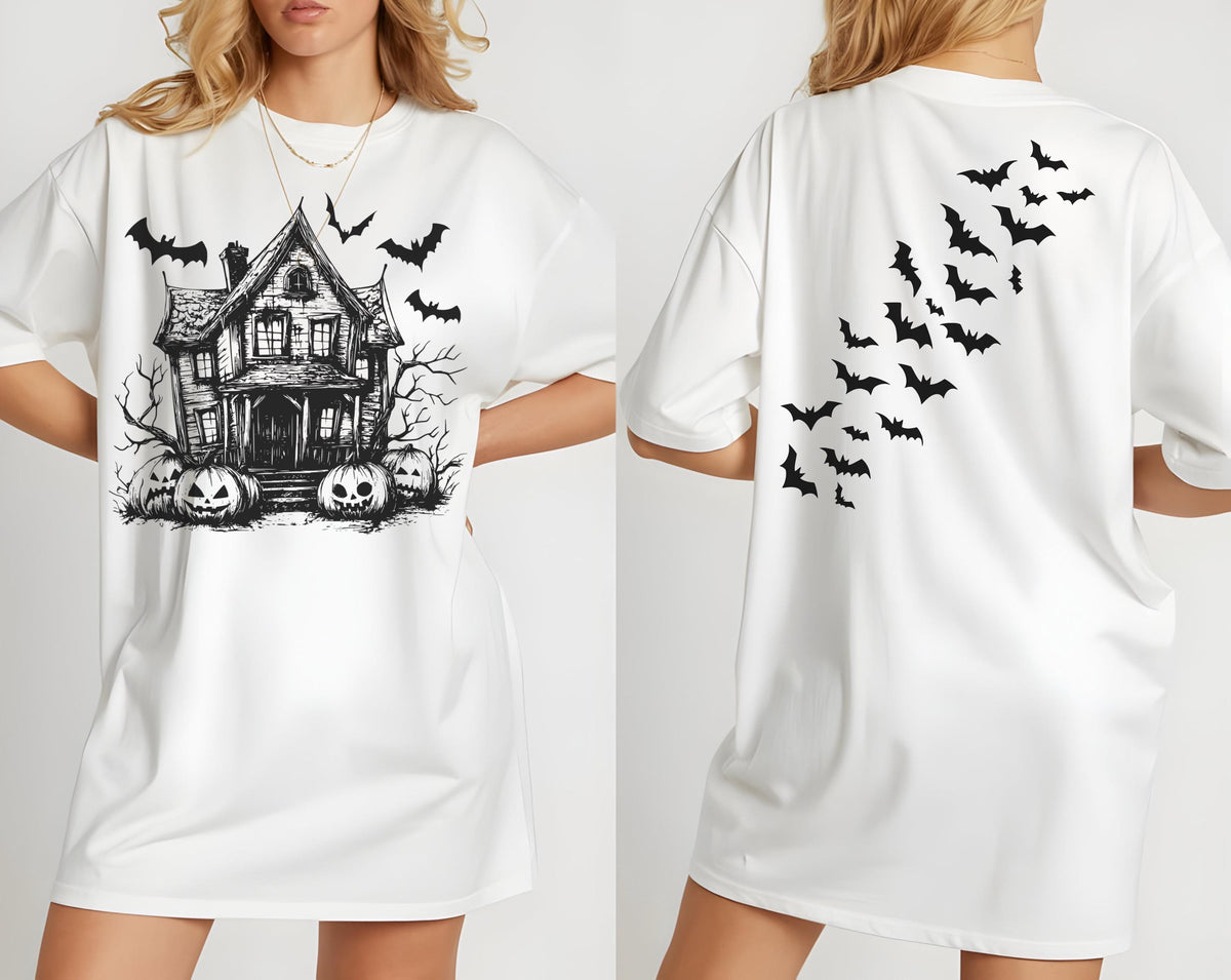 May include: White oversized t-shirt featuring a black and white haunted house graphic with pumpkins and bats. The back of the shirt has a design of black bats in flight. A Halloween-themed graphic tee.