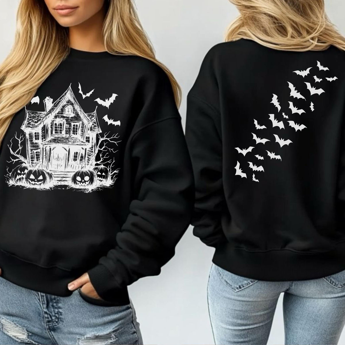 May include: Black sweatshirt featuring a white haunted house, bats, and jack-o'-lanterns graphic on the front. The back of the sweatshirt has a white bat design. A Halloween-themed apparel item.