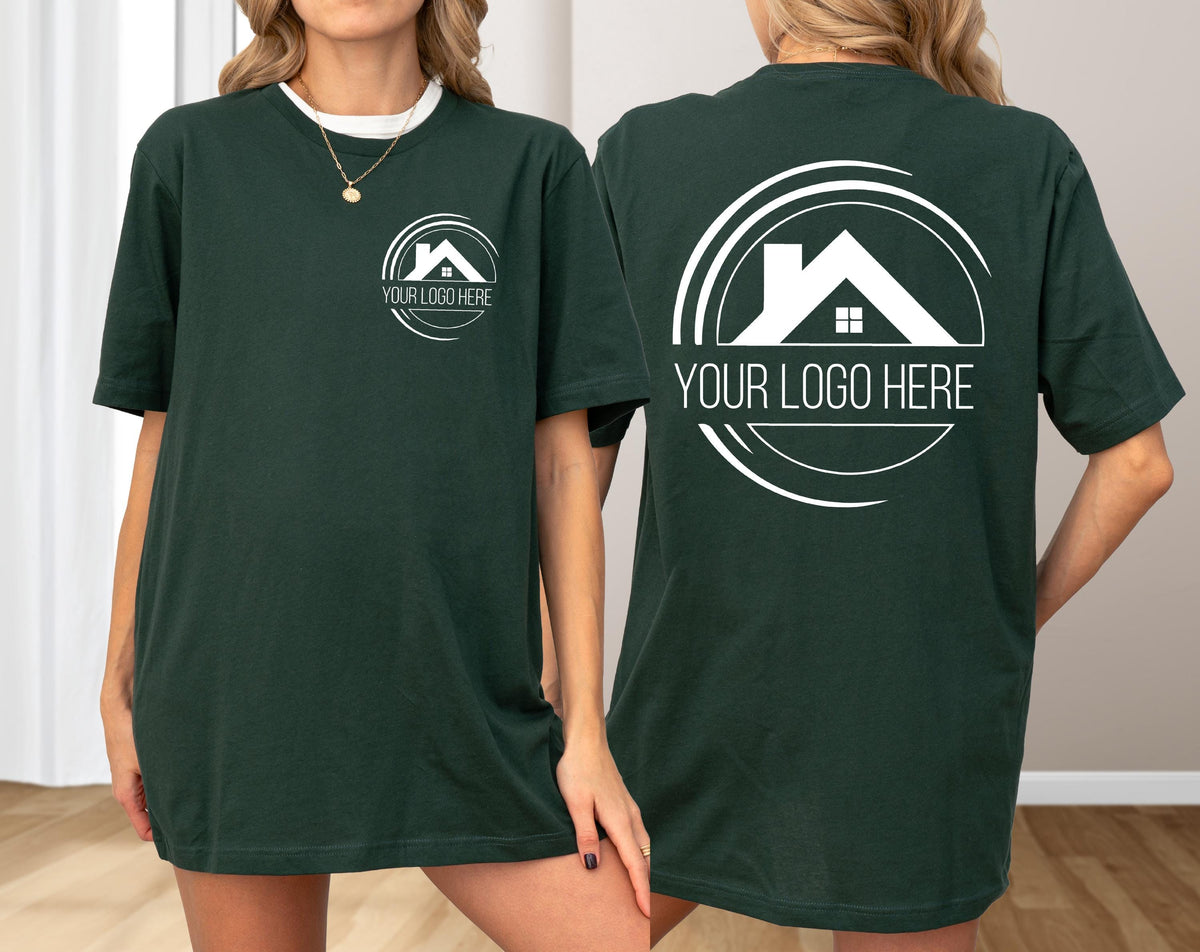 May include: Dark green t-shirts with a white logo featuring a house silhouette inside a circle, with the text "YOUR LOGO HERE". The shirts are short-sleeved and have a relaxed fit. The logo is on the front and back of the shirts.