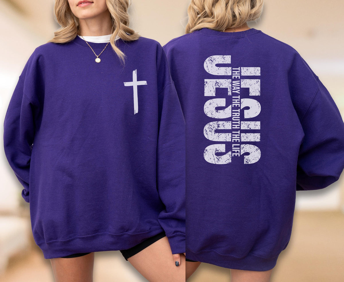 May include: A purple sweatshirt with a white cross on the front and the text "JESUS THE WAY THE TRUTH THE LIFE" on the back. The sweatshirt is a solid color and has a crew neck.