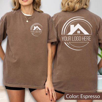 May include: Espresso-colored t-shirt with a white logo on the front and back. The logo features a house silhouette within a circular design, with the text "YOUR LOGO HERE". The shirt is a short-sleeved, casual style.