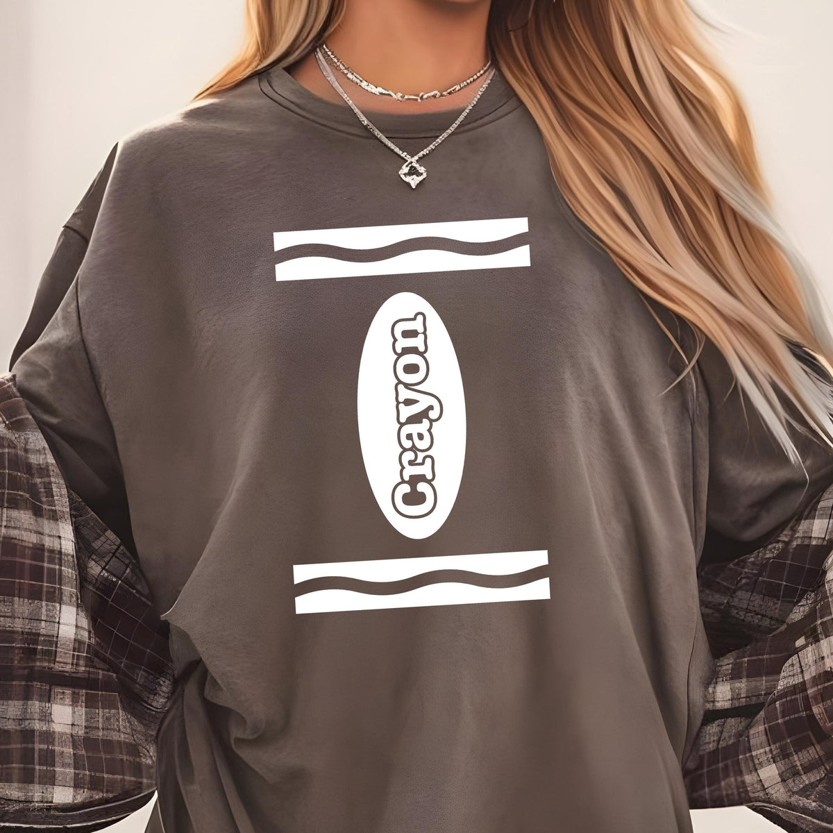 May include: A dark gray crewneck sweatshirt featuring a white graphic design on the chest. The graphic consists of two horizontal wavy lines and a central vertical oval containing the word Crayon in white, sans-serif, capital letters.