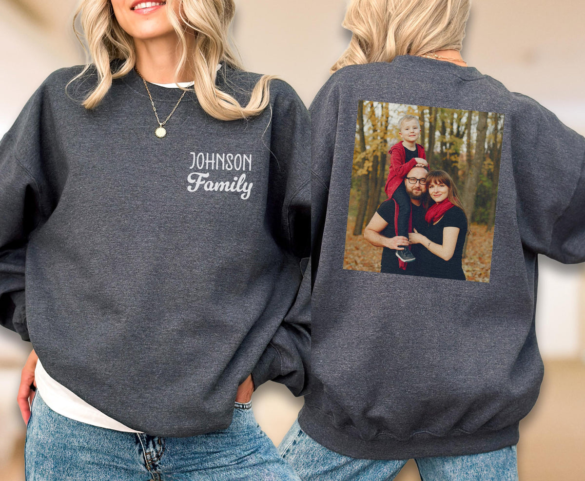 May include: A dark gray sweatshirt with the embroidered text "JOHNSON Family" on the front. The back of the sweatshirt features a family photo. The sweatshirt is a comfortable, casual garment.