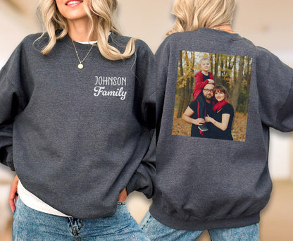 May include: A dark gray sweatshirt with the embroidered text "JOHNSON Family" on the front. The back of the sweatshirt features a family photo. The sweatshirt is a comfortable, casual garment.