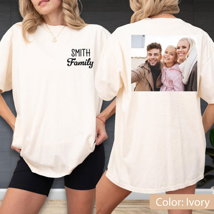 May include: Ivory-colored t-shirt with the text "SMITH Family" printed on the front. The back of the shirt features a family photo. The shirt is a relaxed fit and has short sleeves. The color is ivory.