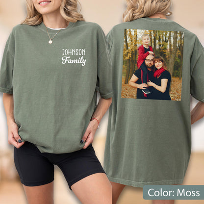 May include: Moss green t-shirt with "Johnson Family" printed on the front. The back of the shirt features a family photo. The shirt is a relaxed fit and has short sleeves. The color is described as "Moss".