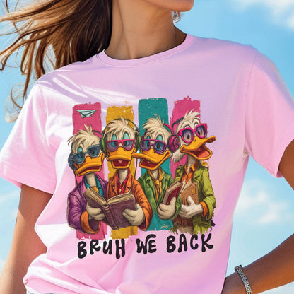 May include: Pink t-shirt featuring a cartoon image of four ducks wearing glasses and headphones, each holding a book. The ducks are set against colorful vertical stripes. The text "BRUH WE BACK" is printed below the ducks.
