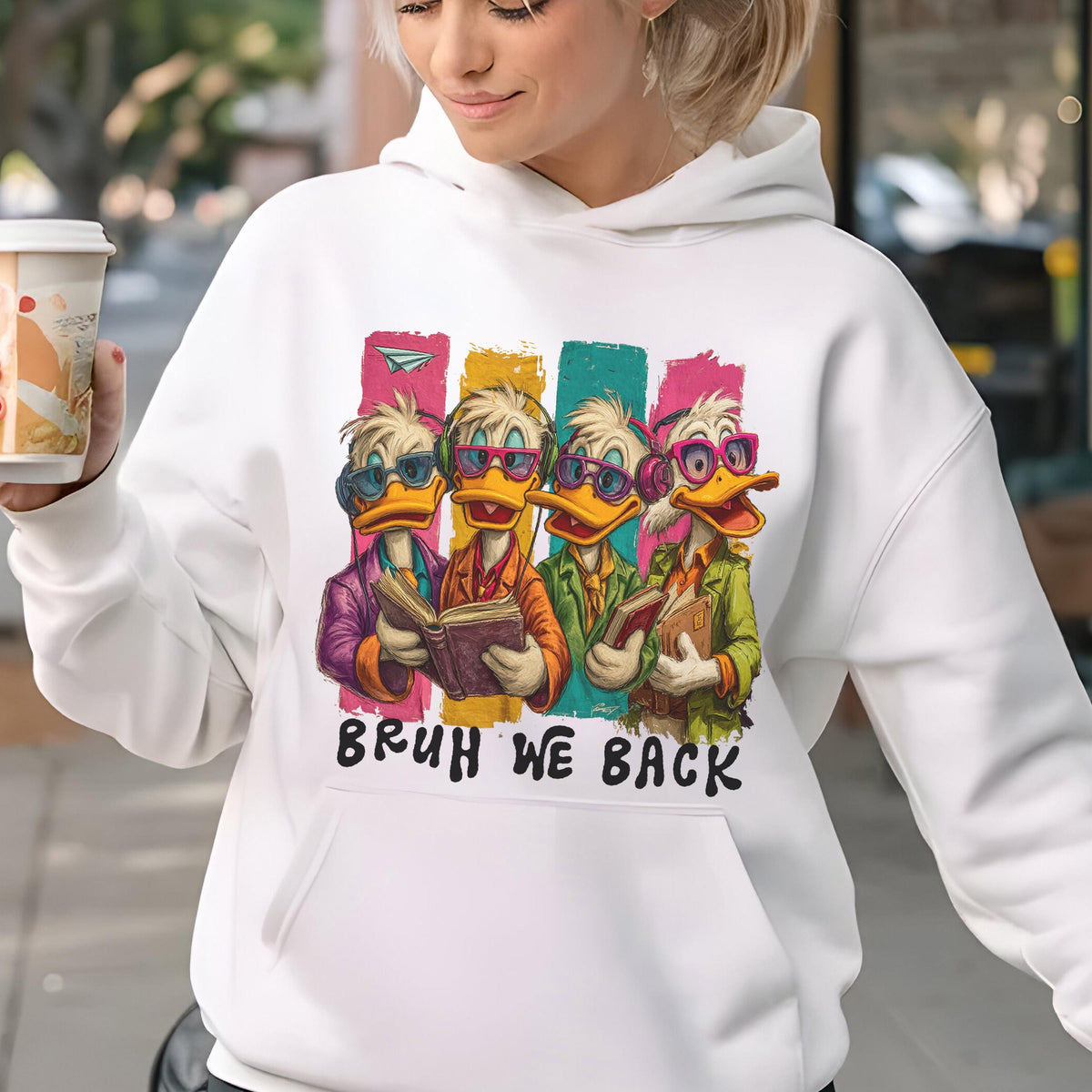 May include: White hoodie featuring a cartoon design of four ducks wearing sunglasses and reading books, with colorful vertical stripes behind them. The text "BRUH WE BACK" is printed below the ducks.