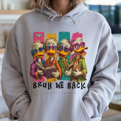 May include: A light gray hoodie featuring a cartoon illustration of four ducks wearing glasses and holding books. The ducks are set against colorful vertical stripes. The text "BRUH WE BACK" is printed below the illustration.