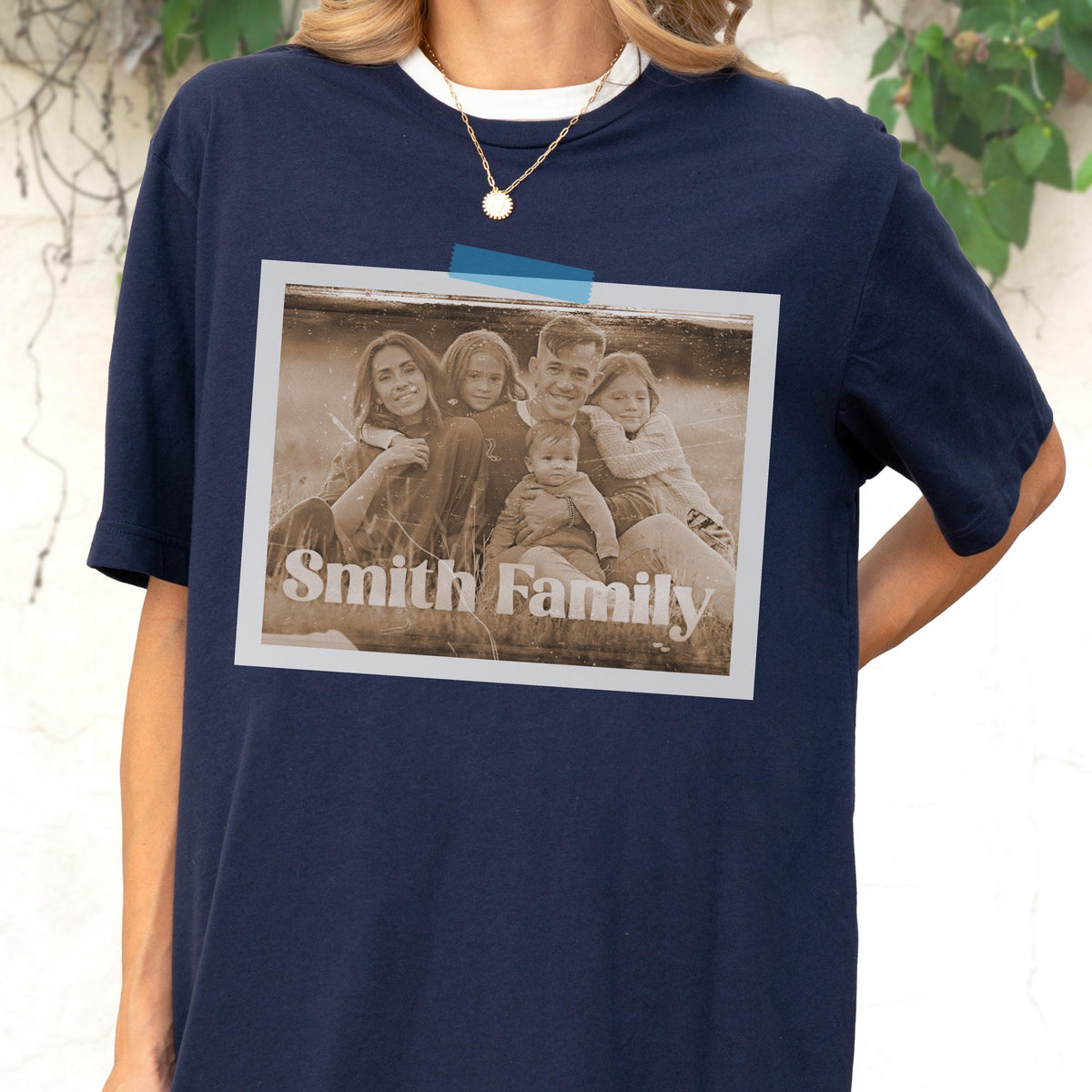 May include: Navy blue t-shirt with a white collar featuring a sepia-toned family photo. The photo is taped to the shirt and has the words "Smith Family" printed on it. The shirt is a casual style.