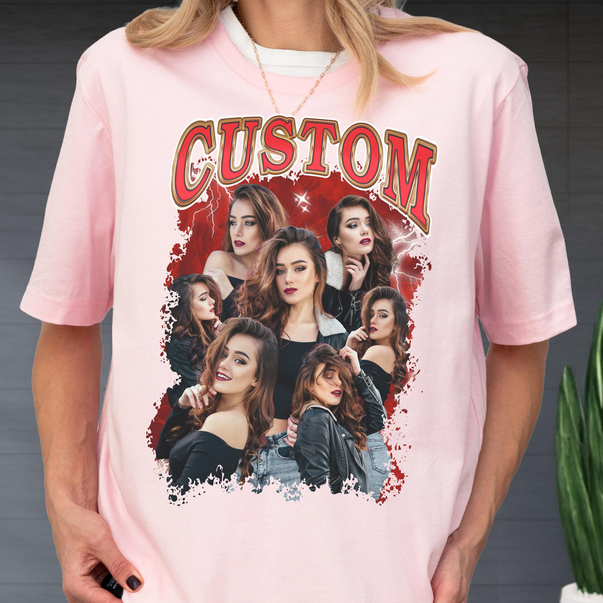 May include: Pink t-shirt featuring a graphic design with the word "CUSTOM" in red and gold lettering. The design includes multiple images of a woman with long brown hair, set against a red background with lightning bolt accents. The shirt has short sleeves.
