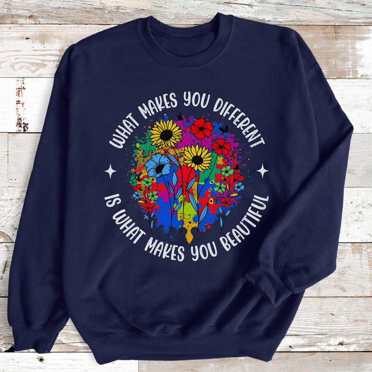May include: Navy blue sweatshirt with a colorful floral design. The design includes sunflowers, red flowers, and blue flowers. The text "WHAT MAKES YOU DIFFERENT IS WHAT MAKES YOU BEAUTIFUL" is printed around the floral design.