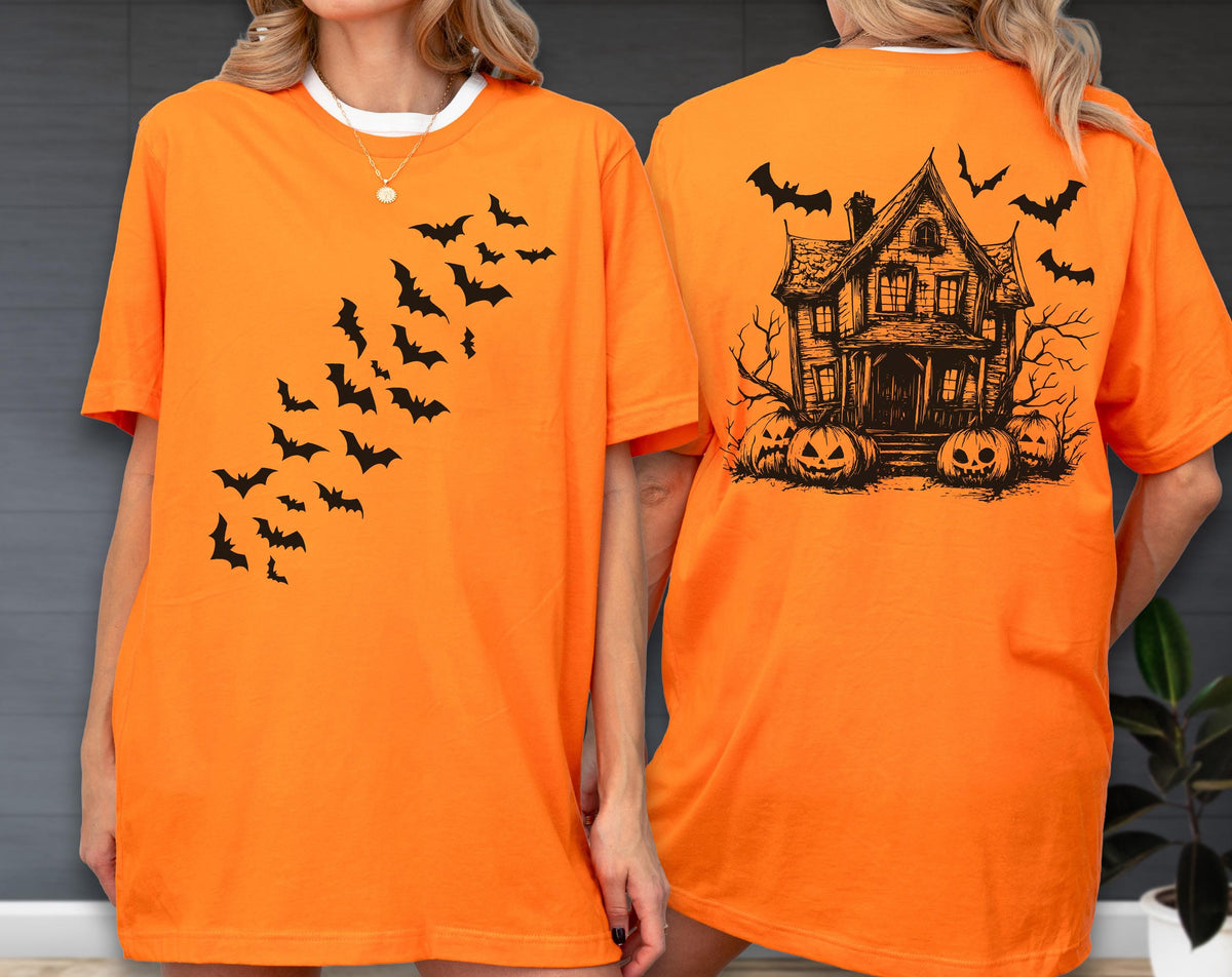 May include: Orange t-shirt with a black bat design on the front and a haunted house graphic on the back. The front features a diagonal pattern of bats. The back displays a spooky house, pumpkins, and more bats.