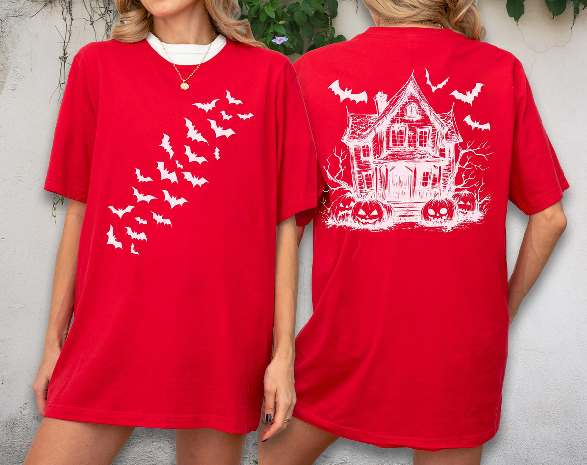 May include: Red t-shirt with white graphics. The front features a flock of bats, while the back displays a haunted house, pumpkins, and more bats. The shirt has a white collar and is perfect for Halloween.