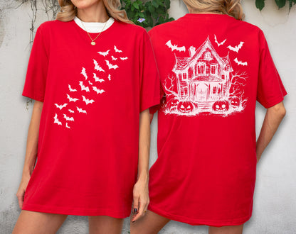 May include: Red t-shirt with white graphics. The front features a flock of bats, while the back displays a haunted house, pumpkins, and more bats. The shirt has a white collar and is perfect for Halloween.