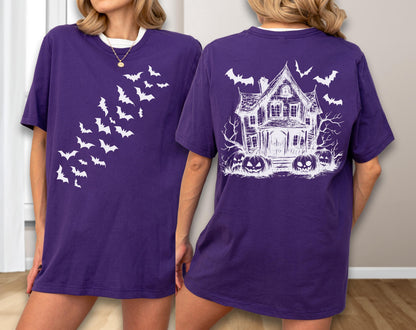May include: Purple t-shirt with white graphics. The front features a flock of bats, while the back displays a haunted house, bats, and jack-o'-lanterns. The shirt has a white collar.