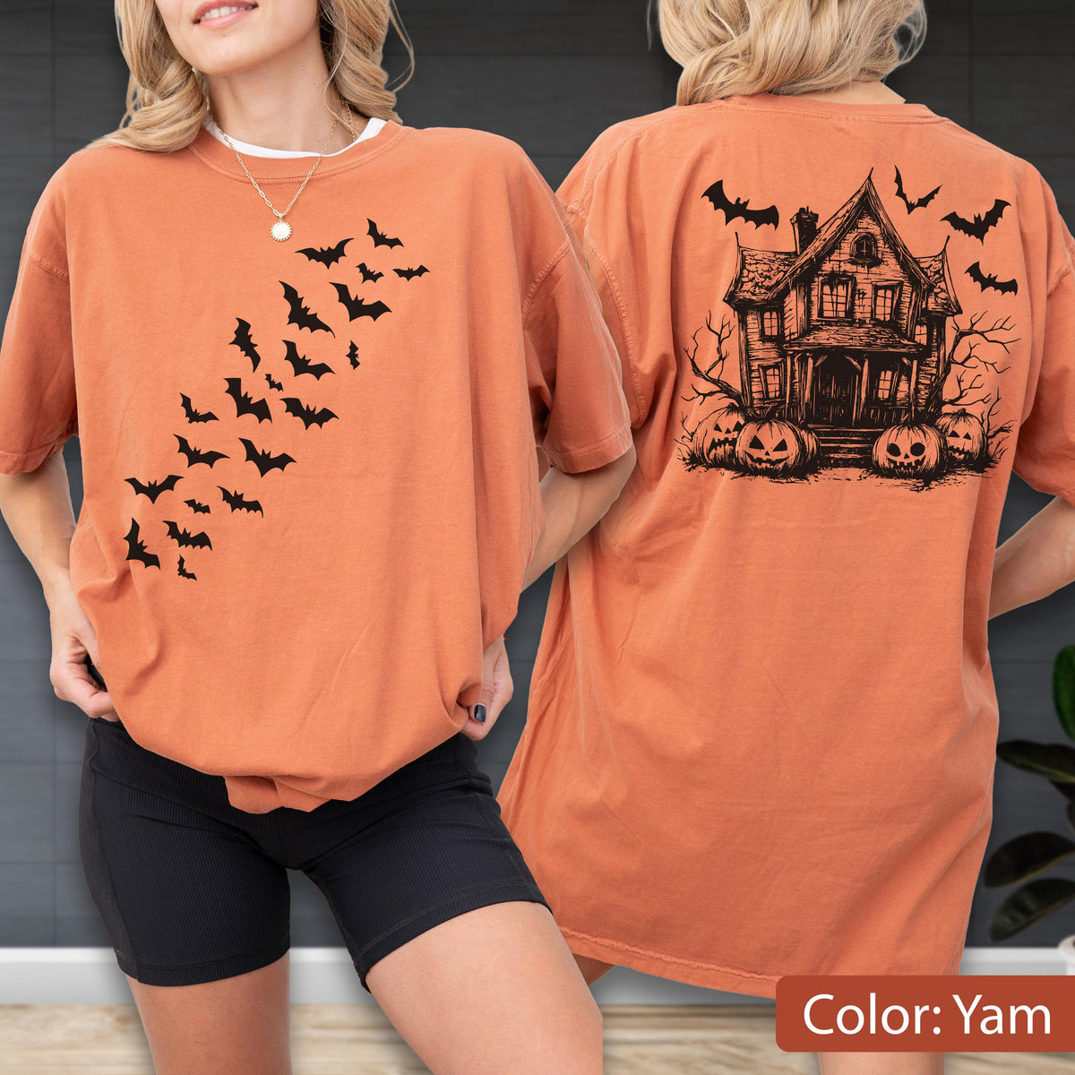 May include: An orange t-shirt featuring a black graphic of a swarm of bats on the front chest. The back of the shirt displays a detailed black illustration of a haunted house surrounded by bare trees and several carved jack-o'-lantern pumpkins.