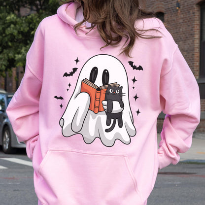 May include: Pink hooded sweatshirt featuring a white ghost reading a book with a black cat. The ghost, cat, bats, and stars are black. The book is orange. The sweatshirt has a front pocket and a hood.