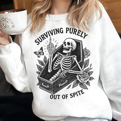 May include: White sweatshirt with a black and white graphic of a skeleton in a coffin, giving the middle finger. The text reads "SURVIVING PURELY OUT OF SPITE". A butterfly and roses are also in the design.
