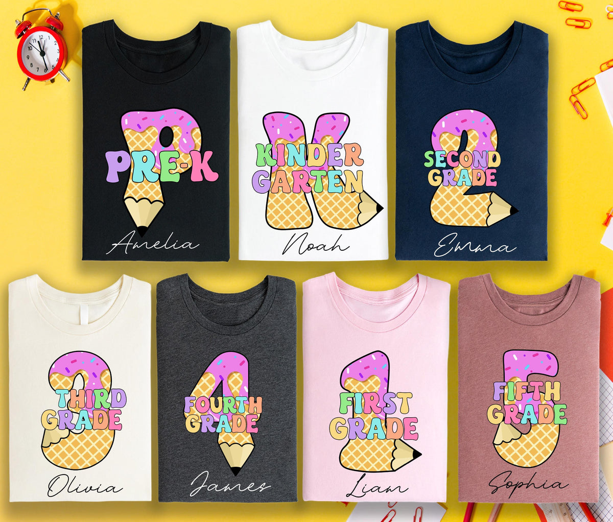 May include: A collection of t-shirts in various colors, each featuring a grade level design. The designs include the grade level, a pencil, and a name. The shirts are for Pre-K, Kindergarten, 2nd, 3rd, 4th, 1st, and 5th grade.