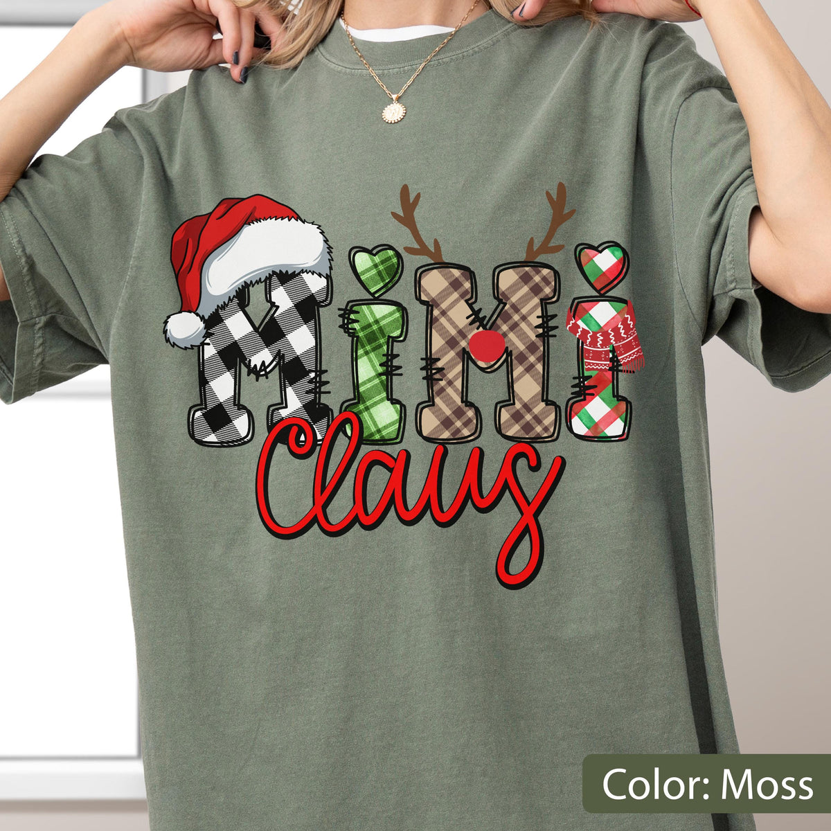 May include: A moss green short-sleeve t-shirt featuring a graphic print that reads Mimi Claus. The letters are decorated with black and white buffalo plaid, green plaid, brown plaid, and red plaid patterns, topped with a red Santa hat and antlers.
