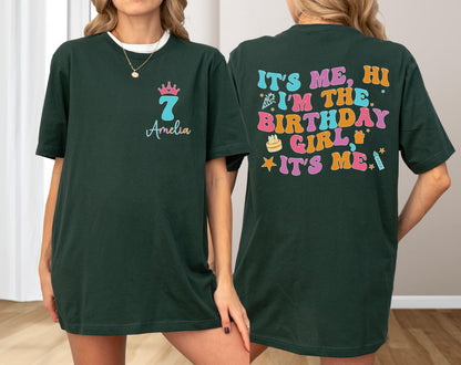 May include: Dark green t-shirt with the text "It's Me, Hi I'm The Birthday Girl, It's Me" on the back in colorful retro font. The front features a crown, the number 7, and the name "Amelia" in a matching font.