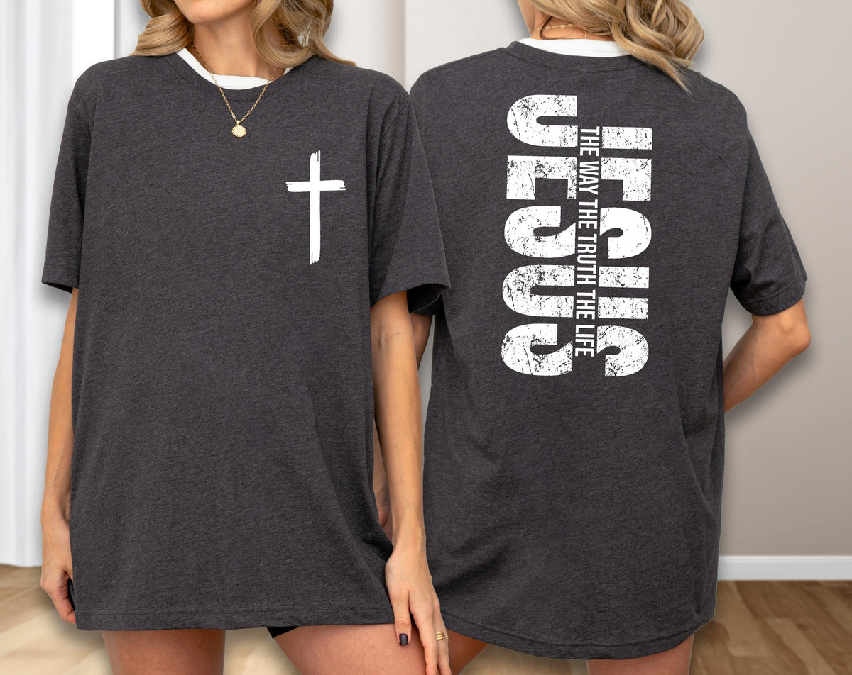 May include: Dark gray t-shirt with a white cross on the front and the word "JESUS" vertically on the back, along with the text "THE WAY THE TRUTH THE LIFE". The shirt has a white neckline.