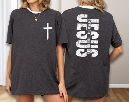 May include: Dark gray t-shirt with a white cross on the front and the word "JESUS" vertically on the back, along with the text "THE WAY THE TRUTH THE LIFE". The shirt has a white neckline.
