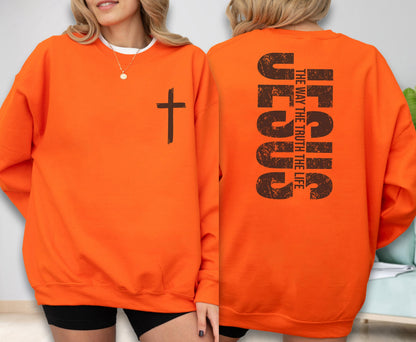 May include: Bright orange sweatshirt with a black cross on the front. The back of the sweatshirt features the word "JESUS" in large, distressed brown letters, with "THE WAY THE TRUTH THE LIFE" printed vertically.