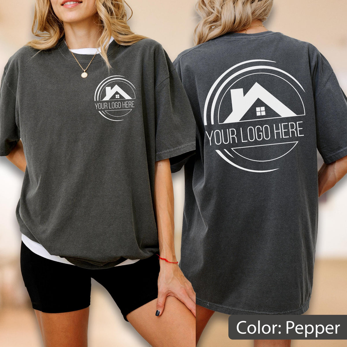 May include: Pepper-colored t-shirt with a white logo on the front and back. The logo features a house icon within a circular design, with the text "YOUR LOGO HERE". The shirt is a relaxed fit, with short sleeves and a crew neck.