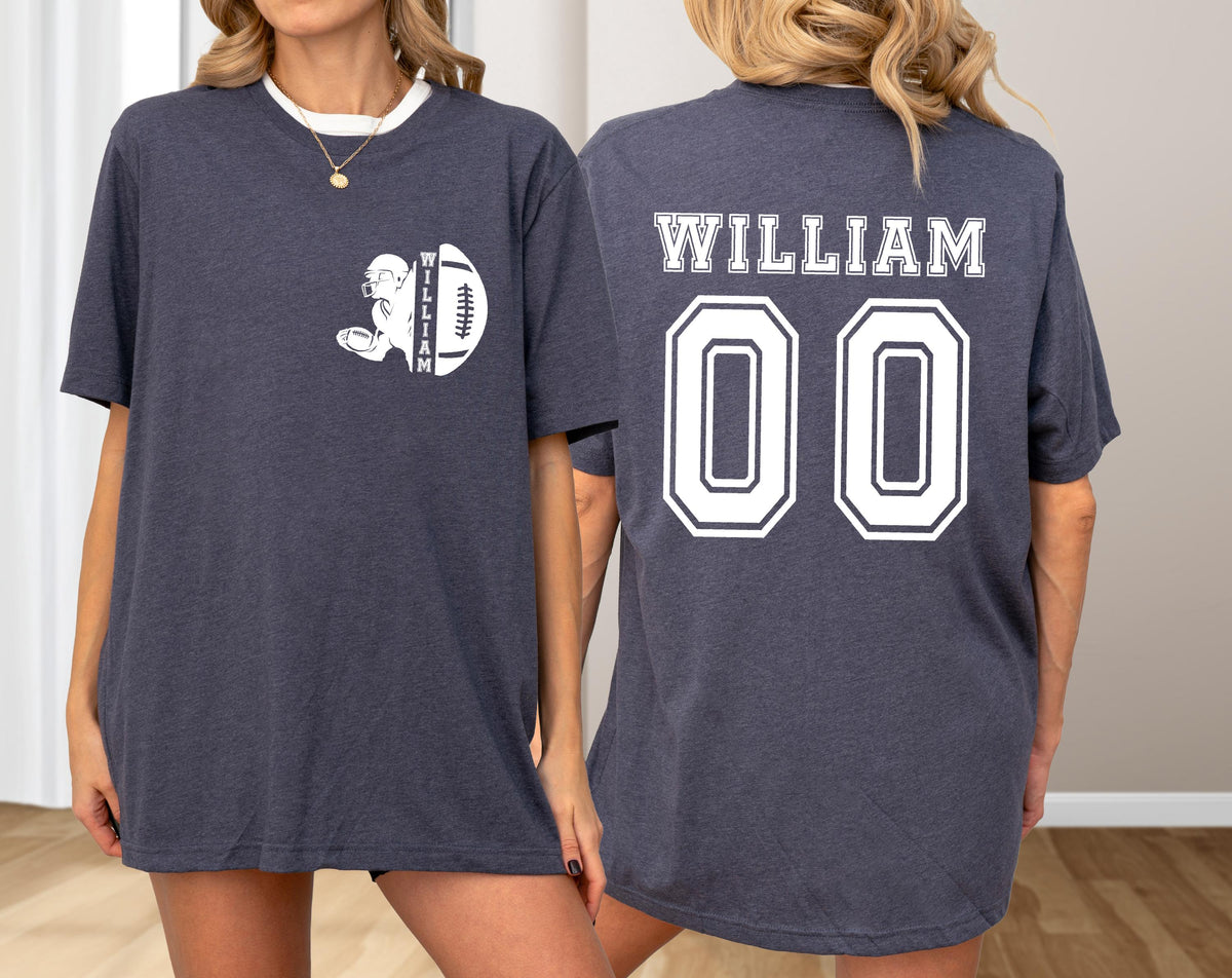 May include: Dark gray t-shirt with a white collar. The front features a football graphic with the name "WILLIAM" and a football. The back displays "WILLIAM" above the number "00" in white.