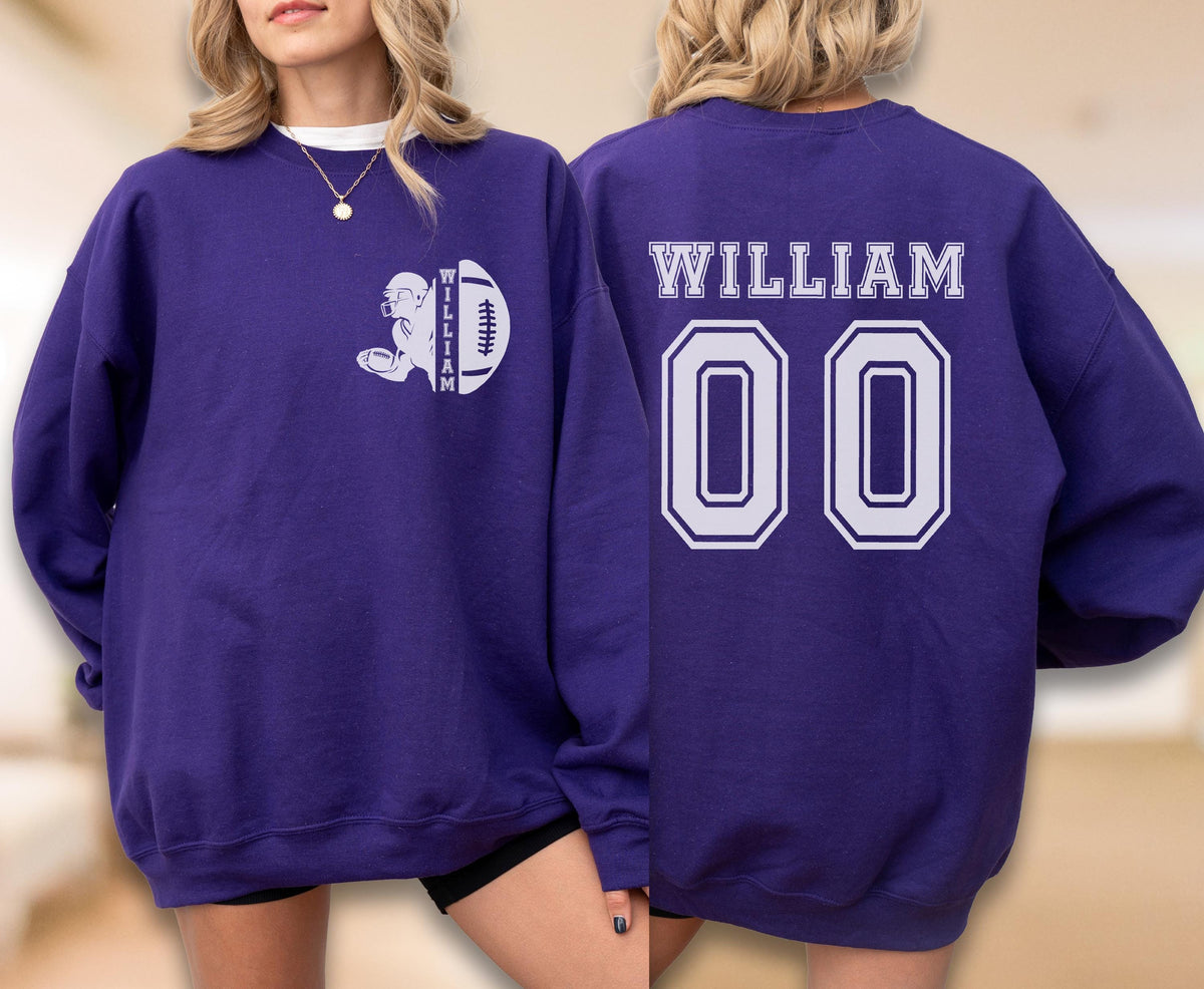 May include: A purple long-sleeve sweatshirt featuring a white graphic on the front left chest of a football player silhouette with the name WILLIAM and a football. The back displays the name WILLIAM in white letters above the large white number 00.