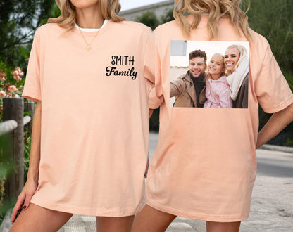 May include: Peach-colored t-shirt with the text "SMITH Family" in black script on the front. The back of the shirt features a family photo. The shirt is a casual, comfortable style.