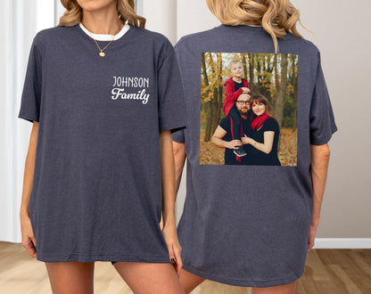 May include: Dark gray t-shirt with a white collar and the text "JOHNSON Family" on the front. The back of the shirt features a family photo. The shirt is a casual, comfortable style.