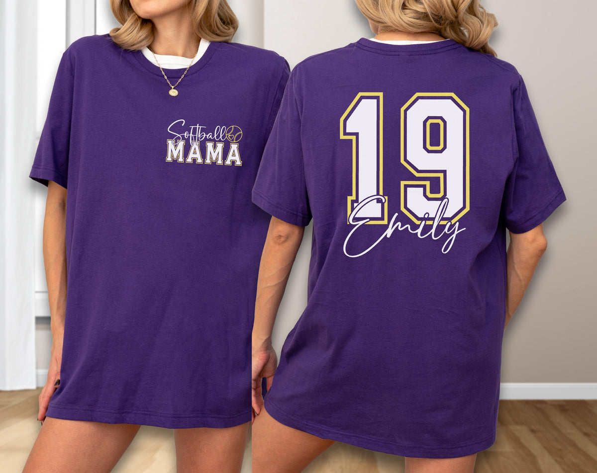 May include: A purple t-shirt with white trim. The front features the text "Softball MAMA" in a stylized font. The back displays the number "19" in white with a gold outline, and the name "Emily" in a script font.