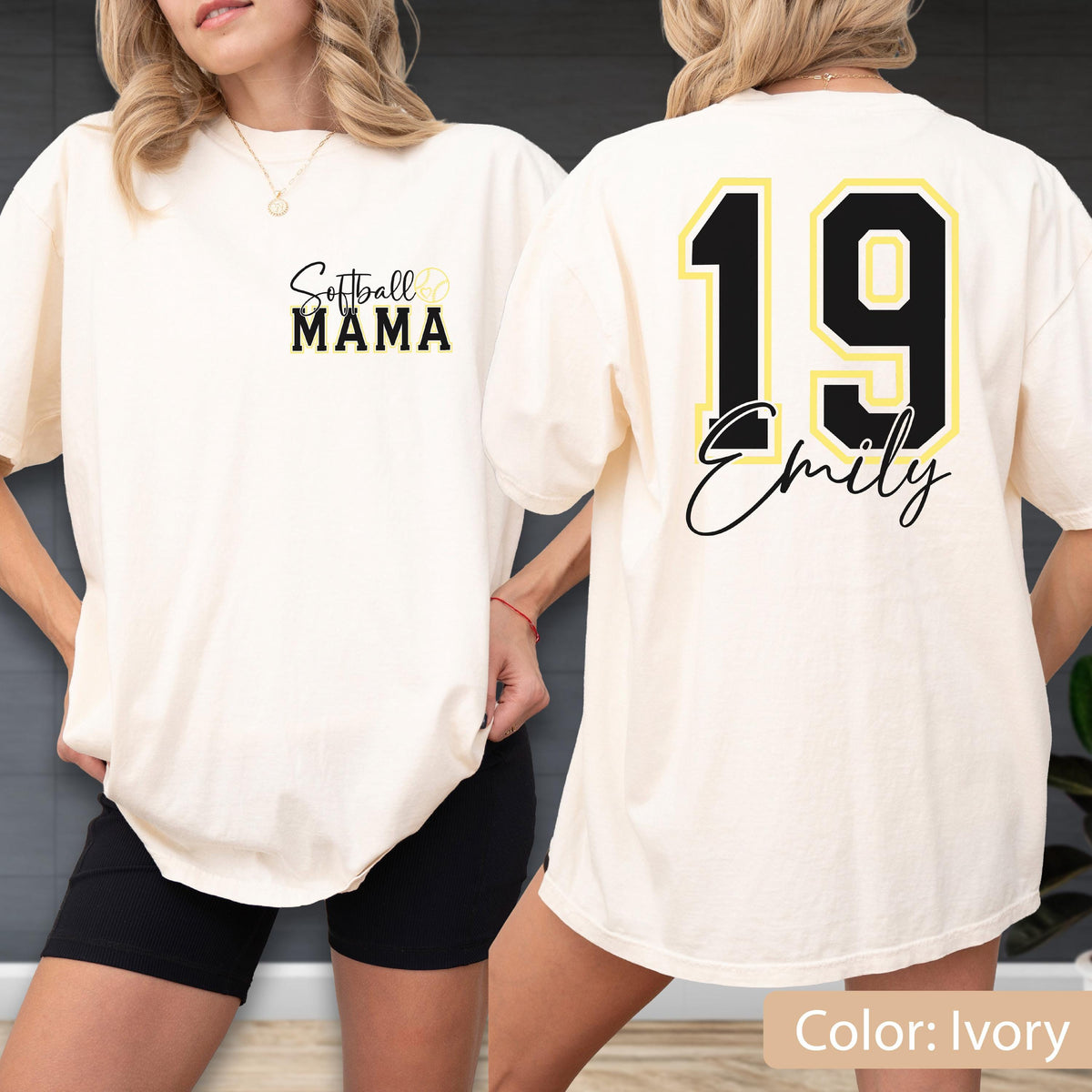 May include: Ivory-colored t-shirt with "Softball Mama" text on the front and a softball graphic. The back features the number 19 in black with a gold outline, and the name "Emily" in script. The shirt is a casual, oversized fit.