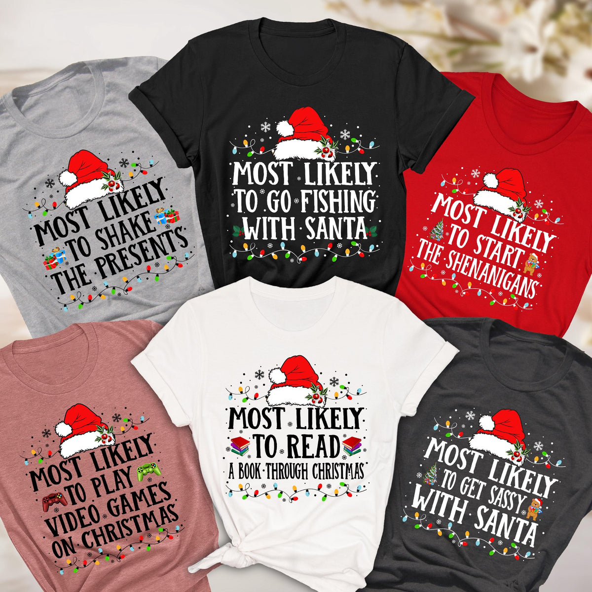 May include: A collection of Christmas-themed t-shirts in various colors, each featuring a Santa hat and the phrase "MOST LIKELY" followed by different holiday activities like "TO GO FISHING WITH SANTA" and "TO SHAKE THE PRESENTS."