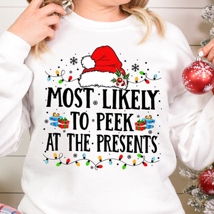 May include: A white long-sleeve sweatshirt featuring a graphic of a red Santa hat, colorful Christmas lights, and small gift boxes. The text reads, "MOST LIKELY TO PEEK AT THE PRESENTS" in black lettering, surrounded by small black snowflake icons.