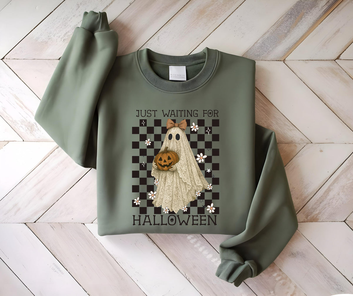 May include: Sage green sweatshirt with a Halloween-themed graphic. The graphic features a ghost holding a pumpkin, set against a checkered background with the text "JUST WAITING FOR HALLOWEEN".